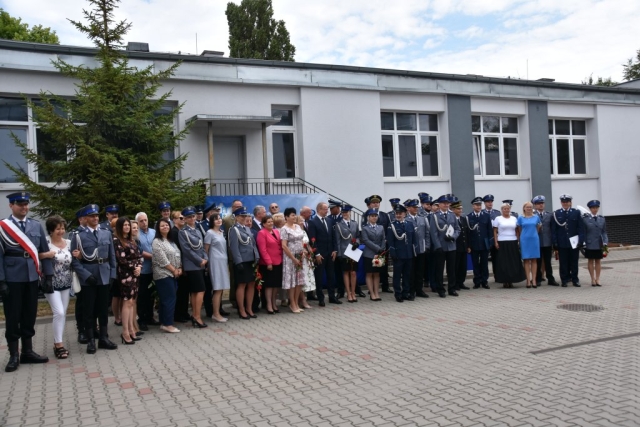 kilkudziesięcioosobowa grupa, wszyscy uczestnicy apelu pozujący do zdjęcia na dziedzińcu komendy, w tle budynek komendy.
