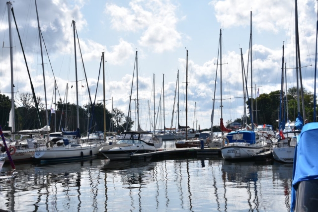 Kilkadziesiąt żaglówek zacumowanych w porcie.