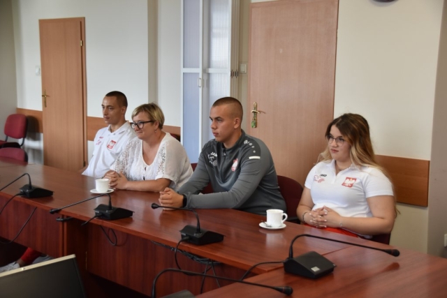 Siedzący przy stole zawodnicy Klubu AKS "Promień" Police, kobieta i mężczyzna, którzy brali udział w zawodach Mistrzostwach Europy U17, wraz z mamą zawodniczki i jednym z trenerów.