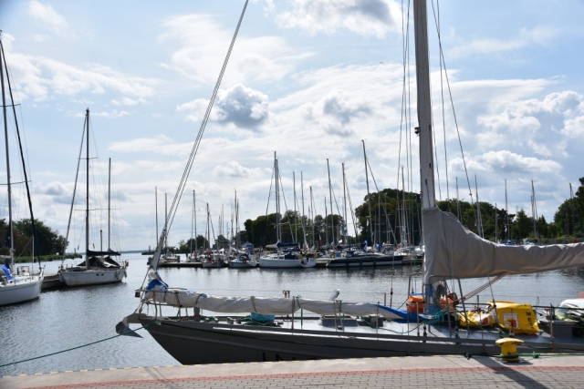 Słoneczna pogoda, jasne chmury na niebie oraz zacumowane łodzie