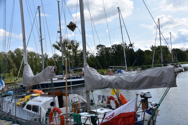 Słoneczna pogoda, jasne chmury na niebie oraz zacumowane łodzie