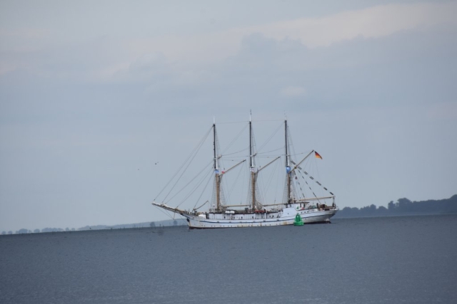 Ciemne niebo zbierające się na deszcz, łódź płynąca po wodzie.