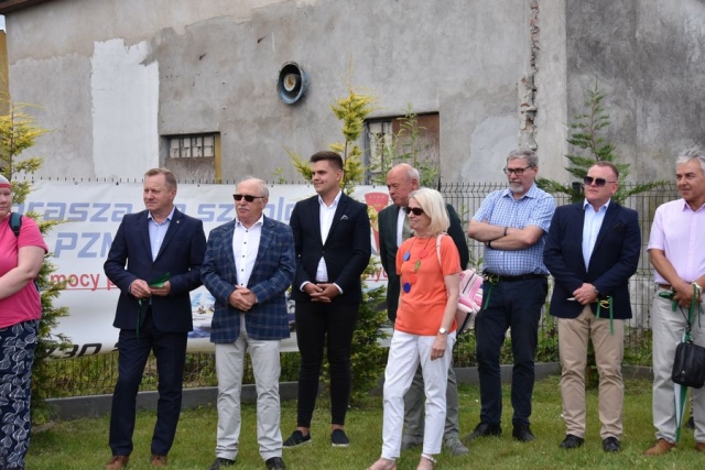 Zaproszeni goście, stojący i słuchający przemówienia