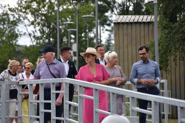 Zaproszeni goście, spacerujący po pomoście wzdłuż rzeki Łarpia
