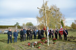 Przedstawiciele samorządów powiatowego i gminnego składają kwiaty pod brzozowym krzyżem