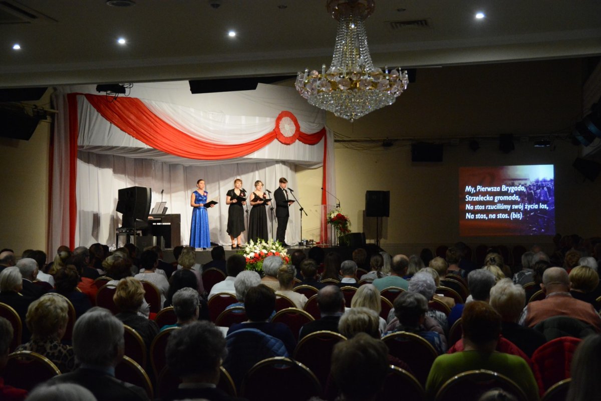 W tle chórzyści śpiewają