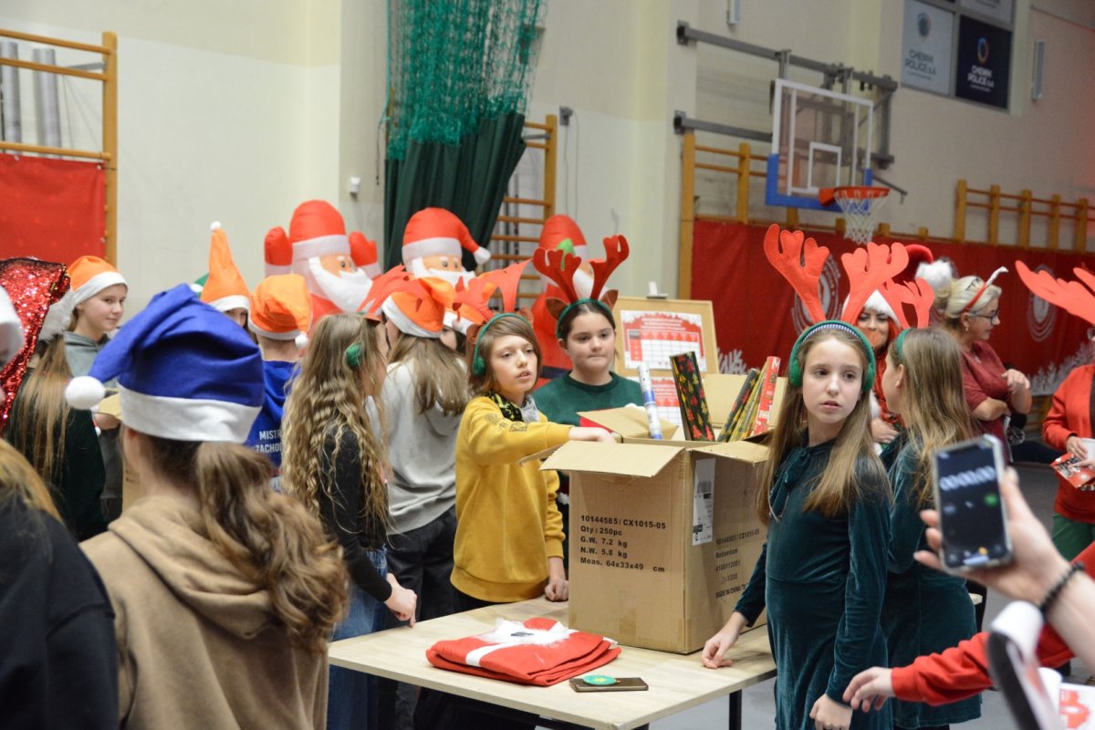 Uczestnicy festynu stoją przy kartonach