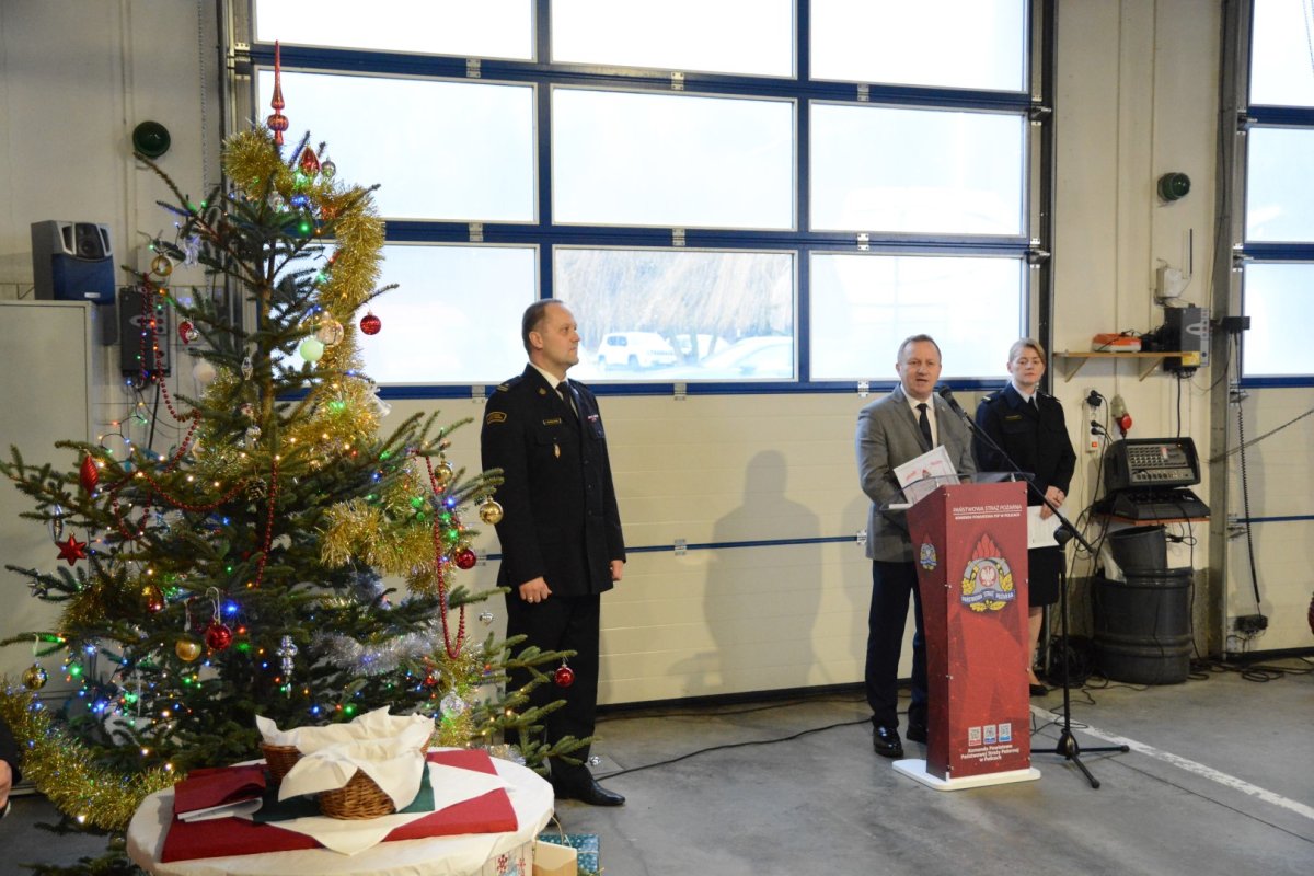 Starosta Policki przy mównicy, obok komendant straży i choinka