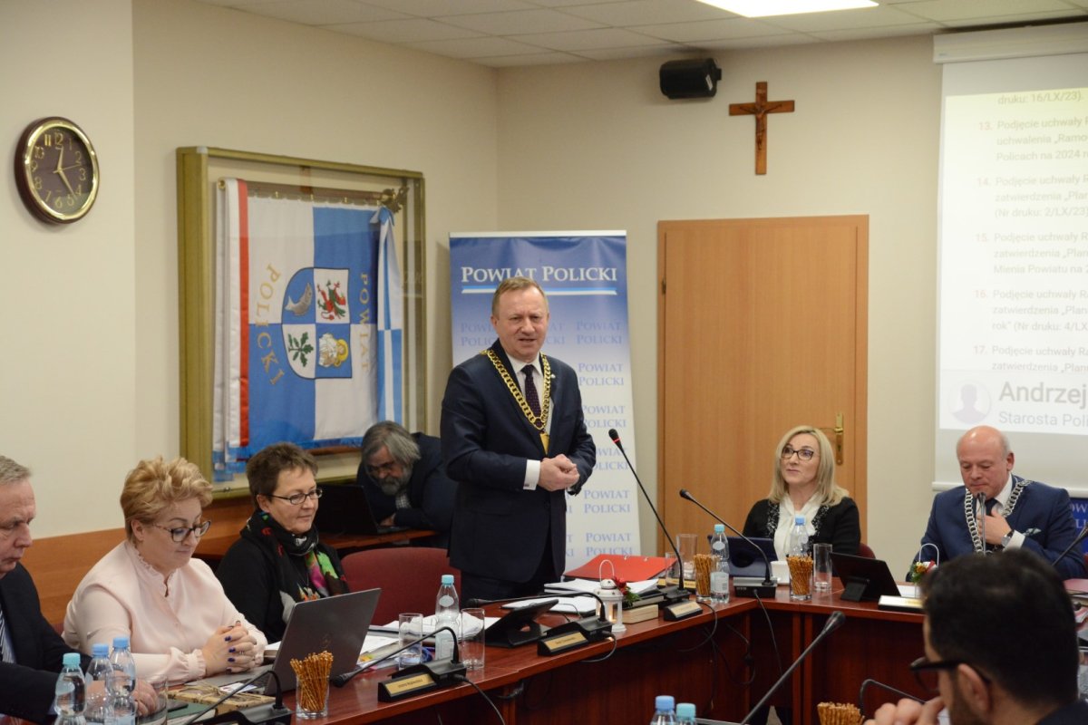 Stojący mężczyzna i obok trzy kobiety siedzące