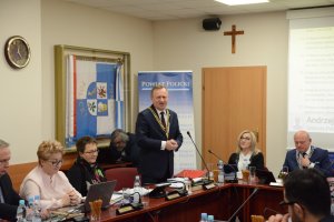 Stojący mężczyzna i obok trzy kobiety siedzące