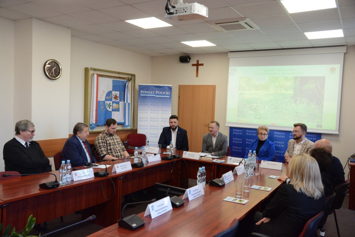 Siedzące osoby przy stole w sali