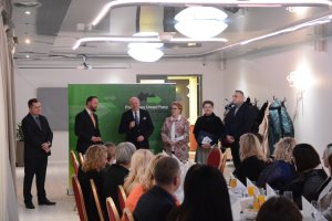 Przedstawiciele Powiatu Polickiego stoją w tle, na pierwszym planie siedzący ludzie