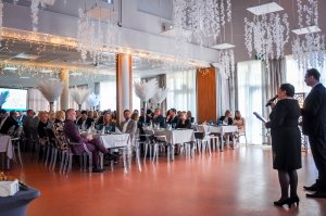 Siędzące osoby w tle, na pierwszym planie dwie osoby stoją