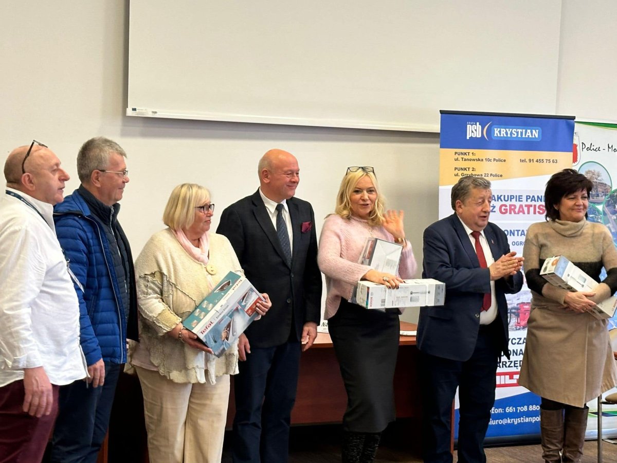 Stojące osoby w rzędzie, po lewej stronie element reklamowy