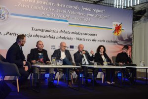 Sześć osób siedzących przy stołach