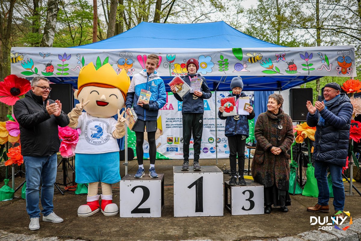 Zawodnicy i wręczający stoją na podium z nagrodami