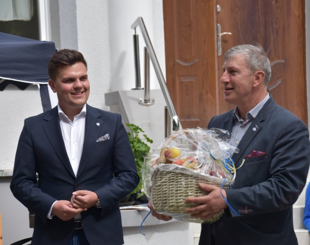 Przedstawiciele Powiatu Polickiego stoją z koszem pełnym jabłek dla uczestników wydarzenia.