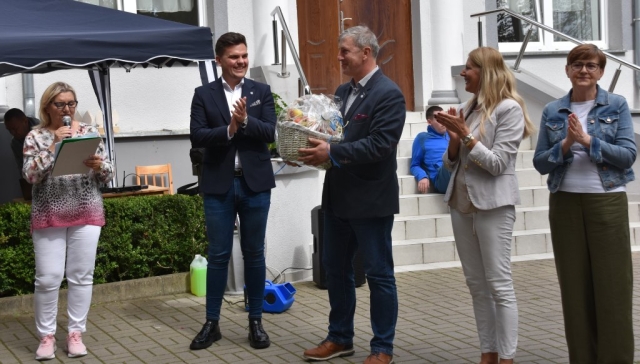 Przedstawiciele Powiatu Polickiego stoją z koszem pełnym jabłek dla uczestników wydarzenia.