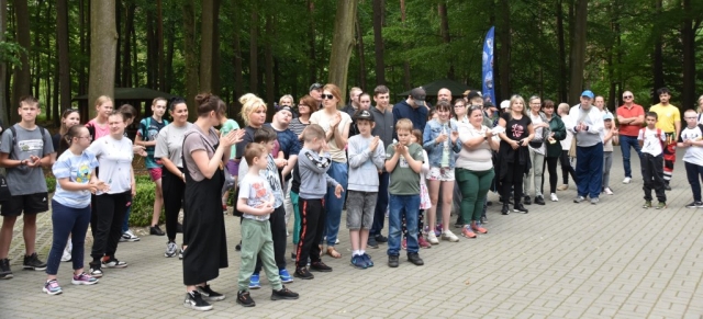 Wychowankowie SOSW w Tanowie klaszczą w ręce wraz z opiekunami.