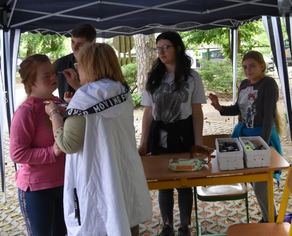 Stoisko z malowaniem twarzy, dziewczynka ma malowaną twarz.