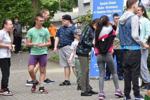 Uczestnicy wydarzenia puszczają bańki mydlane.