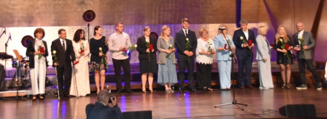Na scenie stoją osoby wyróżnione za wieloletnią działalnośc organizacji