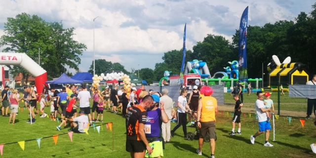 Uczestnicy wydarzenia krzątają się w pobliżu mety biegów.