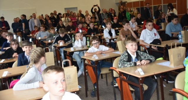 Uczestnicy konkursu pożarniczego siedzą w ławkach