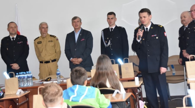 Strażacy wraz z Członkiem Zarządu Powiatu Polickiego poczas przemawiania do uczestników konkursu.