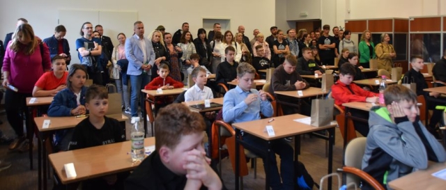 Uczestnicy konkursu pożarniczego siedzą w ławkach