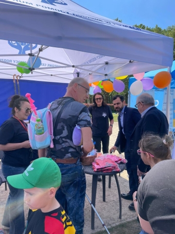 Goście festynu przyglądający się stoisku Powiatowego Centrum Pomocy Rodzinie w Policach.