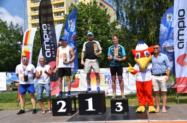 Uczestnicy pozują na podium po ukończonym biegu.
