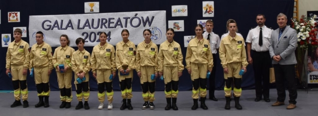 Przedstawiciel Powiatu Polickiego pozuje do zdjęcia z uczniami klasy strażackiej