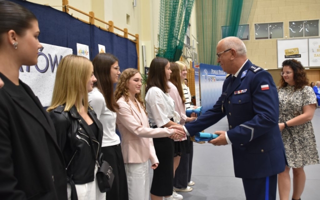 Komendant Powiatowy Policji w Policach Mariusz Bajor składa gratulacje dla nagrodzonych uczniów