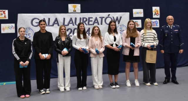 Uczniowie i Komendant Powiatowy Policji w Policach pozują do zdjęcia z nagrodami