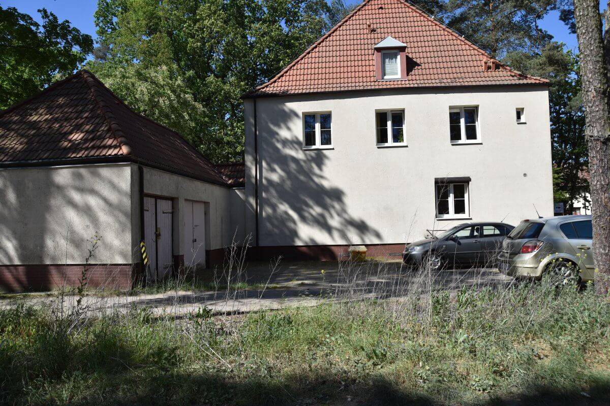 Budynek dwukondygnacyjny ze spadzistym dachem i budynkiem gospodarczym.