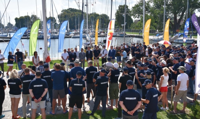 Widok na wodę, zebranych gości oraz uczestników podczas wydarzenia.