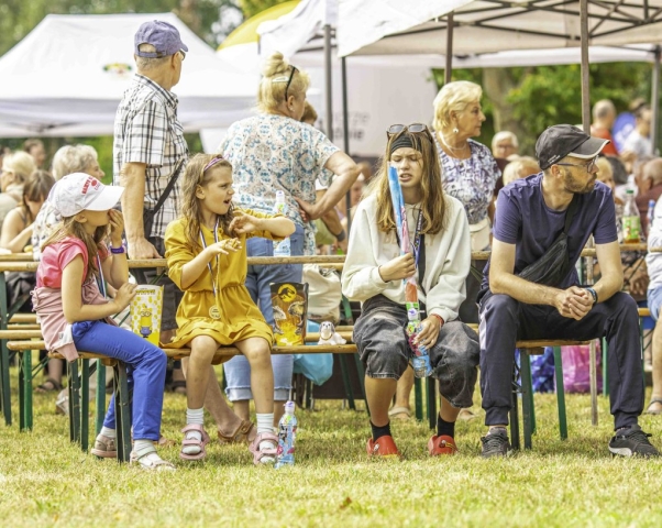 Uczestnicy wydarzenia siedzą przy stoliku, część z nich ma na sobie zdobyte medale.