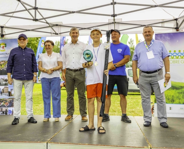 Młody zwycięzca statuetki w Turnieju Wędkarskim na scenie.