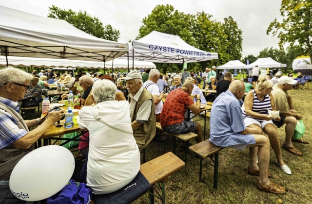 Uczesticy wydarzenia spoczywający przy stołach