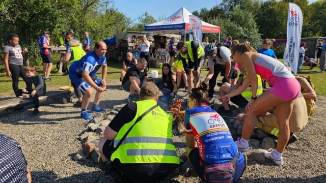 Uczestnicy wspólnie grillują kiełbaski podczas rajdu rowerowego