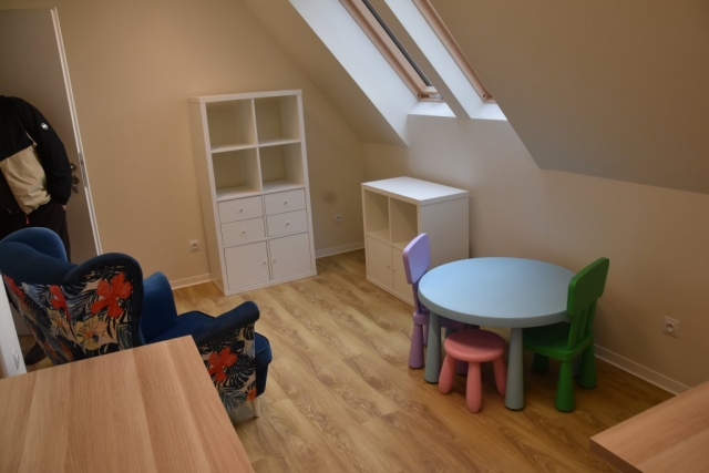 Zdjęcie pokoju, w środku znajdują się białe meble i kolorowy stolik dla dzieci