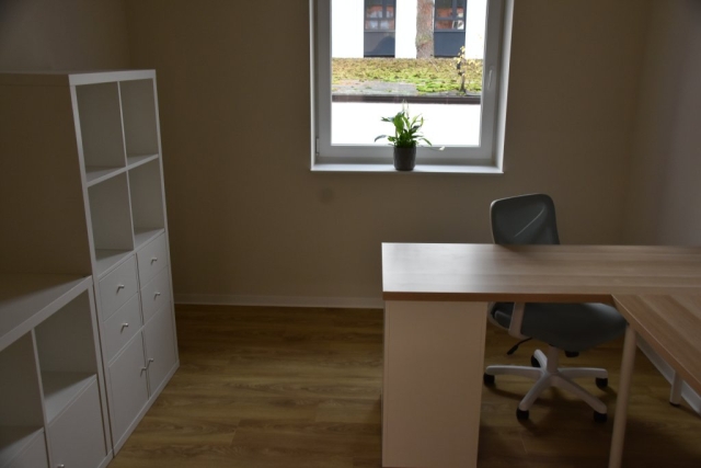 Zdjęcie odremontowanego pokoju, w którym znajdują się jasne meble.