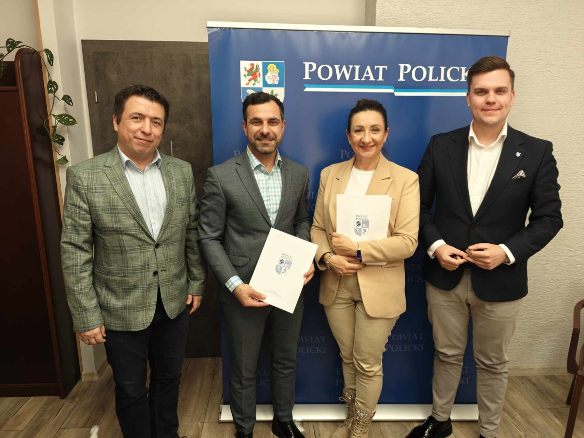 Podpisanie dofinansowania Schroniska dla Bezdomnych Zwierząt w Dobrej, członkowie spotkania pozują z podpisanym dokumentem