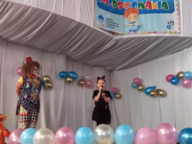 Występ dziewczynki recytującej wiersz na scenie