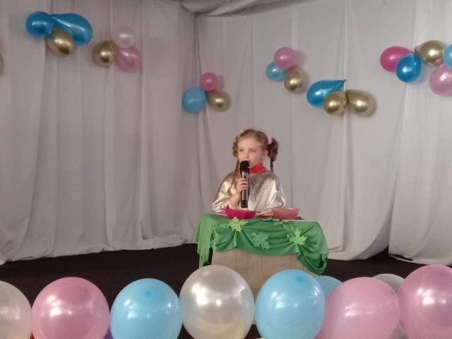 Występ dziewczynki recytującej wiersz na scenie