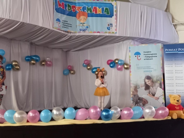 Występ dziewczynki recytującej wiersz na scenie