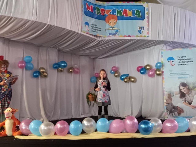 Występ dziewczynki recytującej wiersz na scenie