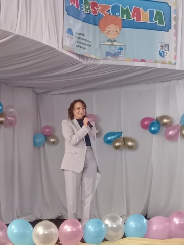 Dyrektor Poradni Psychologiczno-Pedagogicznej w Policach przemawia do mikrofonu na scenie