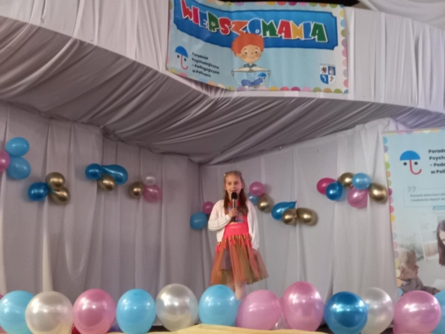 Występ dziewczynki recytującej wiersz na scenie